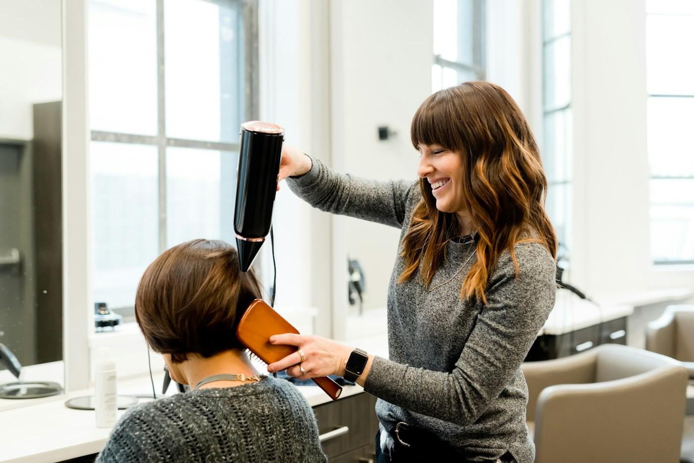 A stylist carefully blow-drying a client’s hair